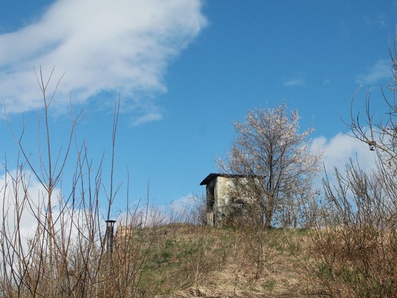 Foto von Hügel mit kleiner Hütte vor blauem Himmel